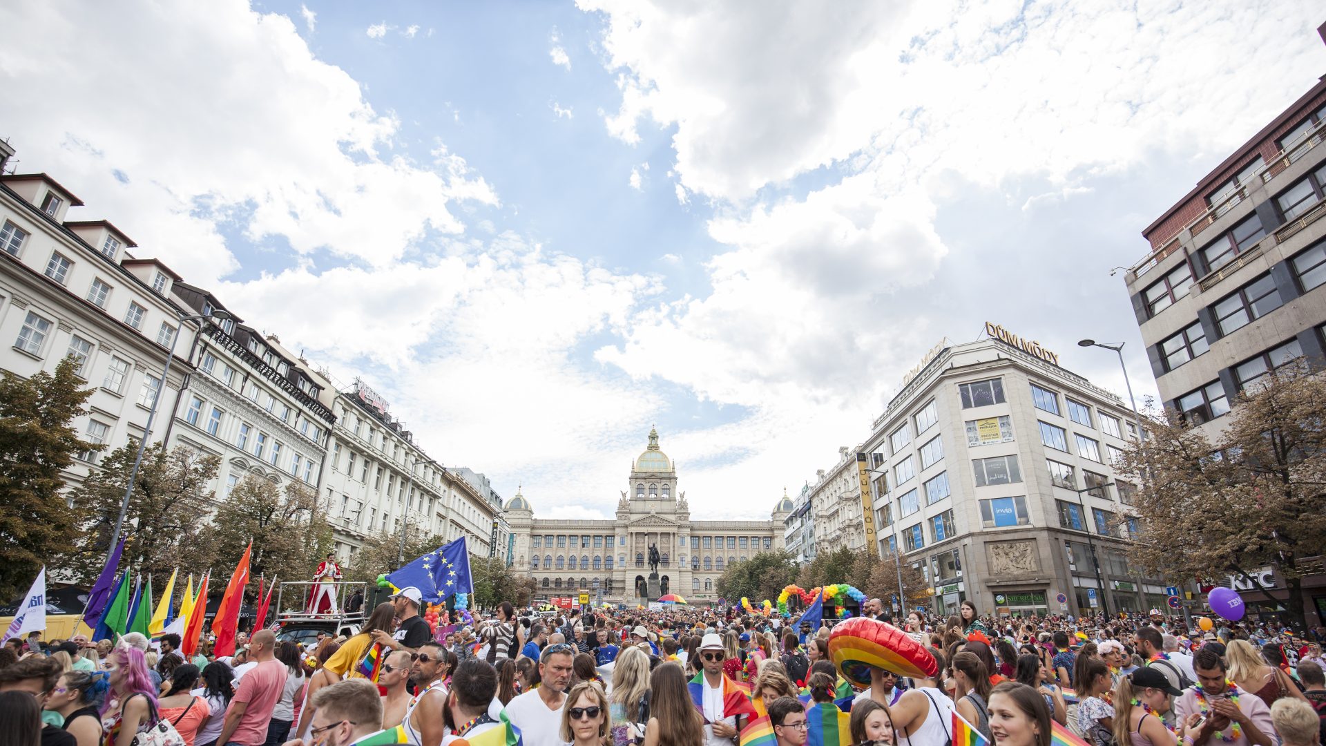 Průvod festivalu Prague Pride na Václavském náměstí - dav duhových lidí a v pozadí Národní muzeum